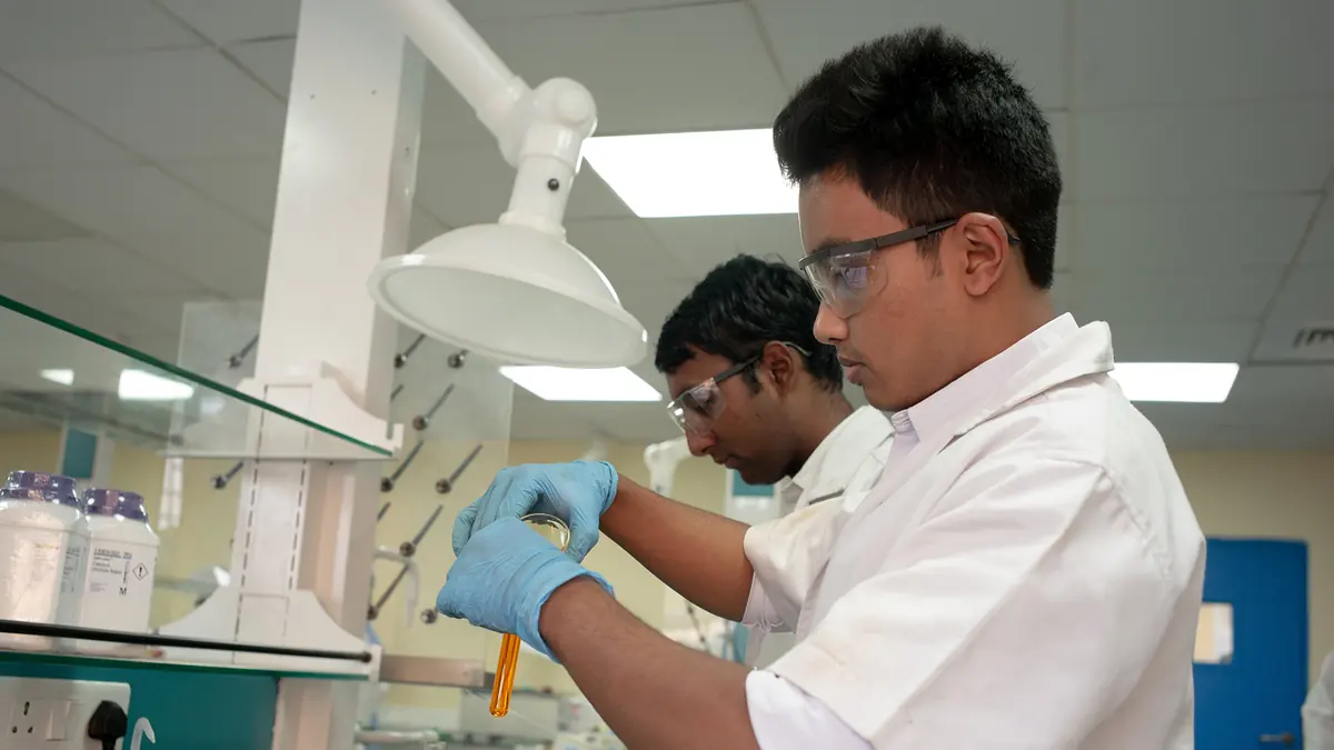 Researchers handling samples in an SSSIHL laboratory