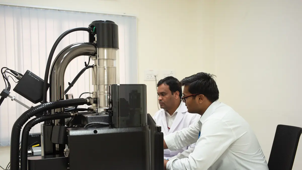 Researchers operating laboratory instruments at SSSIHL