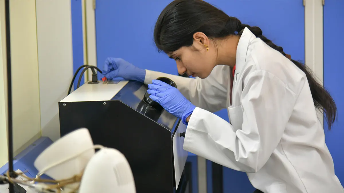 A researcher working with lab equipment at SSSIHL