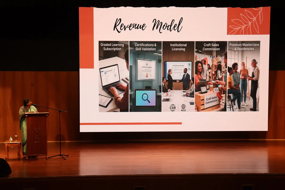 A presenter explaining a revenue model on stage at Startup Day