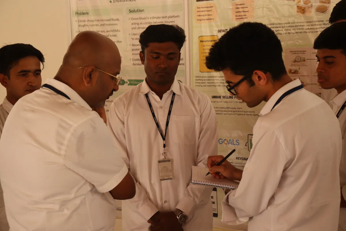 Students explaining their poster to a visitor at the Startup Day poster presentation